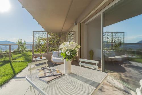a table with a vase of flowers on a patio at La Vista Bonita by Rent All Como in Como