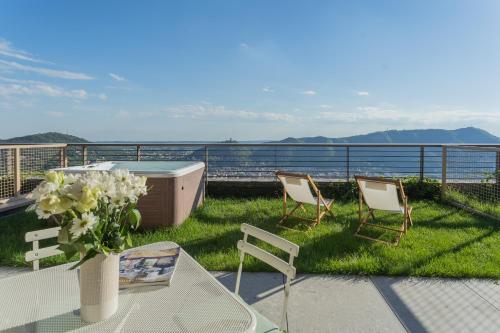 a patio with two chairs and a table with a vase of flowers at La Vista Bonita by Rent All Como in Como