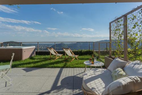a patio with chairs and a couch on a balcony at La Vista Bonita by Rent All Como in Como