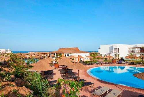 聖瑪麗亞的住宿－Melia Llana Beach Resort & Spa - Adults Only - All Inclusive，一个带游泳池、遮阳伞和椅子的度假村