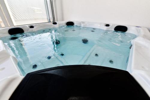 a hot tub with blue water in a room at Apartment Sun in Vir