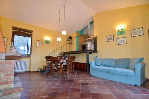 a living room with a blue couch and a table at Agriturismo La Torre dell'Oliveto in Agello