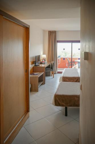 a hotel room with two beds and a living room at Ohtels Campo De Gibraltar in La Línea de la Concepción