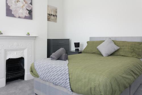 a bedroom with a bed and a fireplace at Boaler House, modern 4 Bed House with parking Sleeps 8 in Liverpool