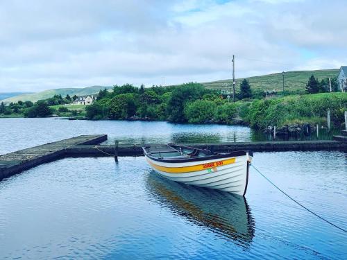 a boat is docked in a body of water at The Lake House Dungloe in Dungloe