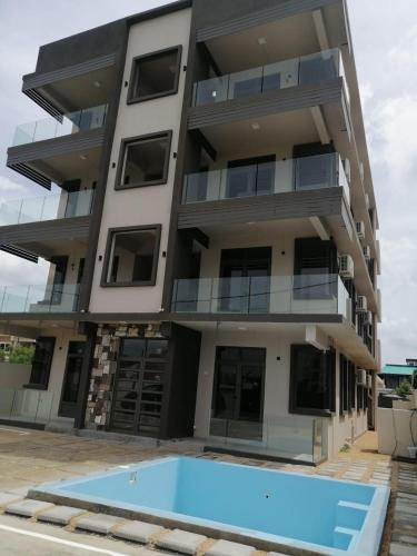 an apartment building with a swimming pool in front of it at Nivi Cosy Appartment in Flic-en-Flac