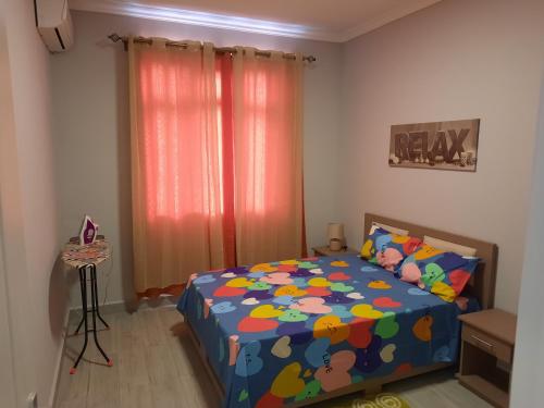 a bedroom with a bed with a colorful comforter at Nivi Cosy Appartment in Flic-en-Flac