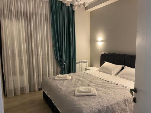 a bedroom with a bed with two towels on it at Home № 1 in Kutaisi