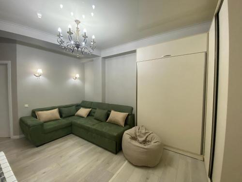 sala de estar con sofá verde y silla en Home № 1 en Kutaisi
