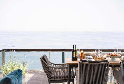 - une table avec de la nourriture et du vin sur un balcon donnant sur l'océan dans l'établissement Divine Residence, a SeaView Retreat, By ThinkVilla, au Pirée