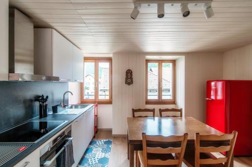 a kitchen with a wooden table and a red refrigerator at Casa Bella Oschesina by Quokka 360 - in the village of Osco in Osco