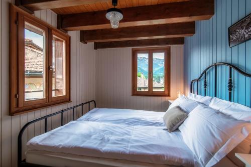 a bed in a bedroom with two windows at Casa Bella Oschesina by Quokka 360 - in the village of Osco in Osco