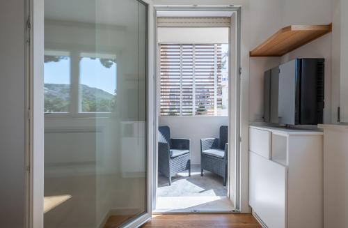 a sliding glass door leading to a living room with a television at Helios Guest House in Cagliari