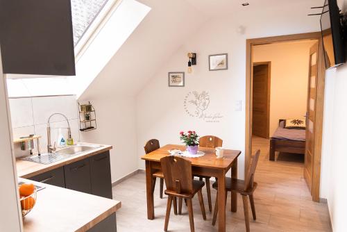 a kitchen and dining room with a table and chairs at Apartamenty Home&Spa in Rabka-Zdrój