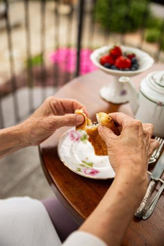 a person eating food on a table with a plate of food at Maison Flipot in Torre Pellice