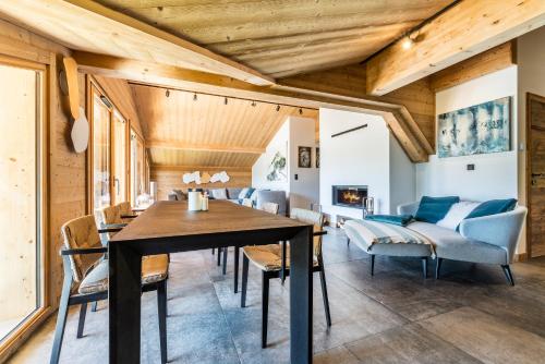 une salle à manger avec un plafond en bois, une table et des chaises dans l'établissement Apartment Tahoe Les Gets - by EMERALD STAY, aux Gets