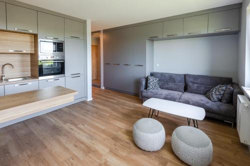 a living room with a couch and a kitchen at Apartment Natura Vision in Opole