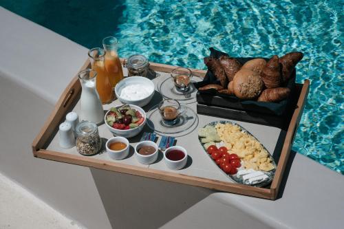 a tray of food on a table next to a pool at Elements Cozy Suites Pyrgos in Pyrgos