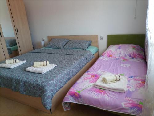 Dos camas en un dormitorio con toallas. en Apartment Princess Sara, en Ohrid