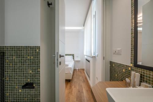 a bathroom with a sink and a toilet and green tiles at Helios Guest House in Cagliari