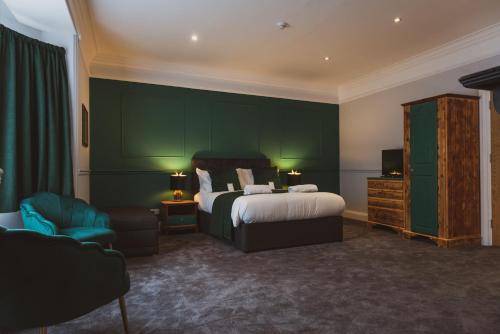 um quarto com uma cama e uma parede verde em The Stag Hotel, Restaurant and Bar em Lyndhurst