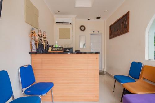 a kitchen with two blue chairs and a counter at Urbanview Hotel Kangen Bungalow Purwakarta by RedDoorz in Maracang-tua