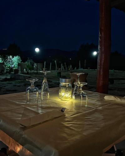 a table with four wine glasses on it at night at Agriturismo Morus Alba Gargano in Foce Varano