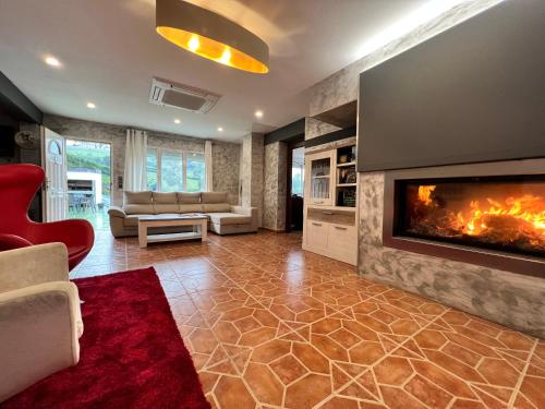 a living room with a fireplace and a red chair at Oviedo Real Spa in Oviedo