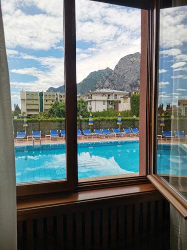 a view of a swimming pool from a window at SunLake Hotel in Riva del Garda