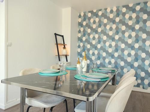 a dining room with a table and chairs and a wall at Le Thourottois*Centre ville*Wifi*Spacieux*Confort* Saint-Gobain in Thourotte