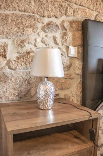 a lamp sitting on top of a wooden table at Casa da Eira de Santo Amaro in Ponte da Barca