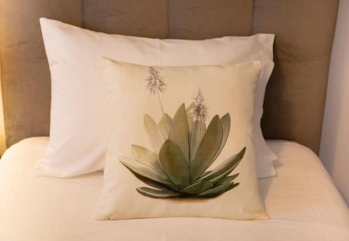 a pillow with a cactus on it on a bed at EntreVillas Alojamento Local, apartamento T2 in Arcos de Valdevez