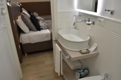 a bathroom with a sink and a toilet and a bed at At your Place in Rome