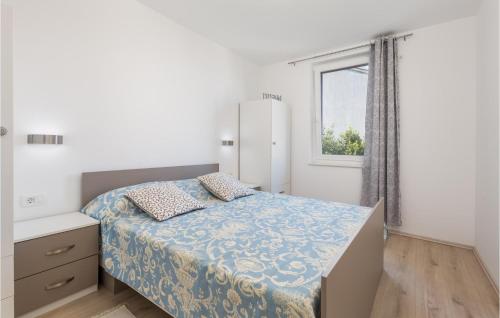 Schlafzimmer mit einem Bett und einem Fenster in der Unterkunft Beautiful Apartment In Lovran With Wifi And 2 Bedrooms in Lovran