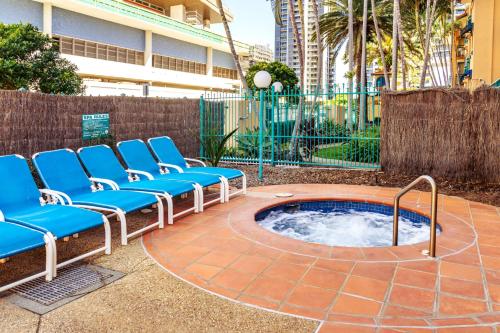 een hot tub in een cirkel met blauwe ligstoelen bij Aruba Sands Resort in Gold Coast