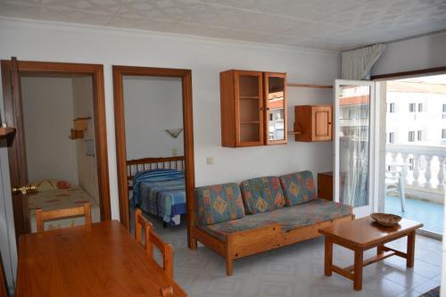 a living room with a couch and a bed and a table at APCOSTAS Europa in Blanes