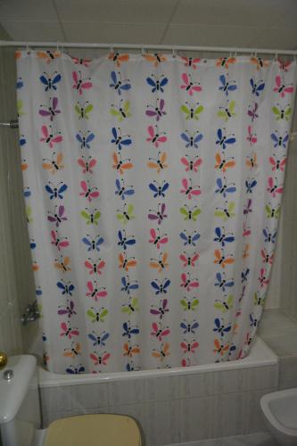 a bathroom with a shower curtain with colorful birds on it at APCOSTAS Europa in Blanes
