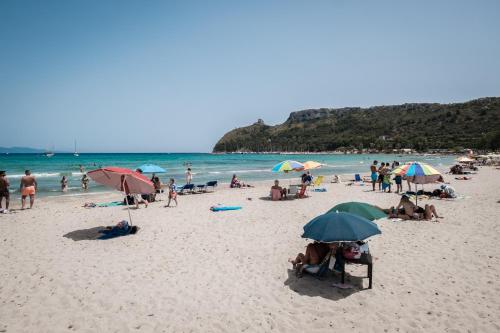 a group of people on a beach with umbrellas at Helios Guest House in Cagliari