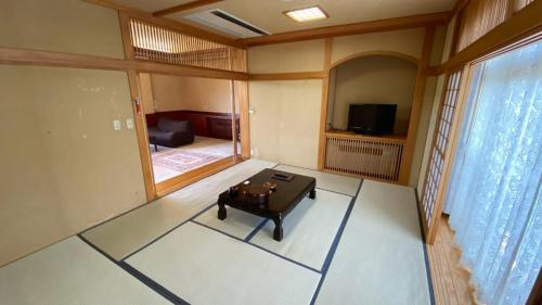 a room with a table in the middle of a room at Tabinoyado Yakurai Rinsenkan in Osaki