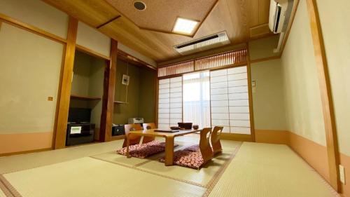 a dining room with a table and chairs at Tabinoyado Yakurai Rinsenkan in Osaki