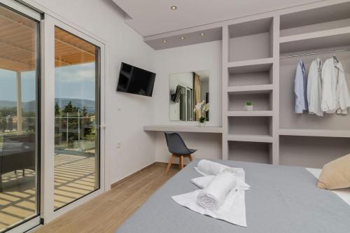 a bedroom with a bed with white towels on it at Villa Johnny in Laganas