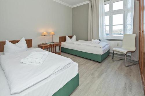 a hotel room with two beds and a chair at Seehof Seehof 31 in Bansin