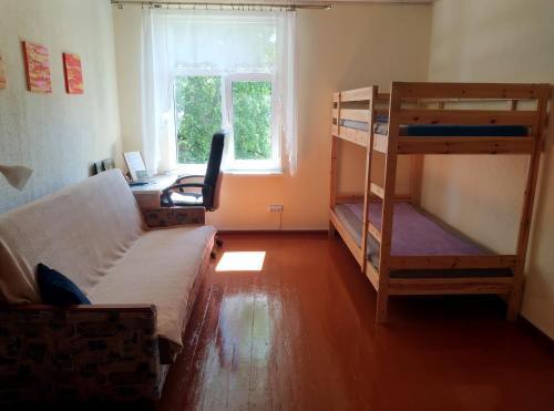 Mazsalaca的住宿－Salisburg Residence，客房设有两张双层床和一张书桌。