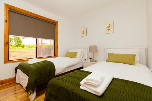 - une chambre avec 2 lits et une fenêtre dans l'établissement Rocky House Pergola Resort, à Rowland Flat