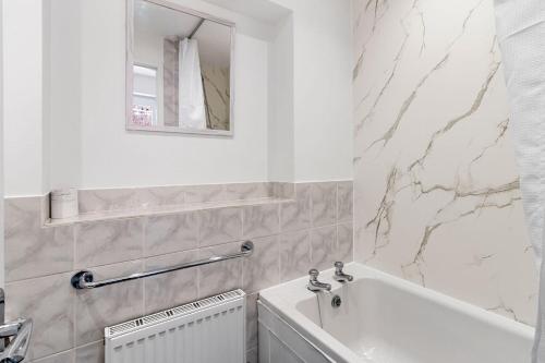 a white bathroom with a tub and a sink at City Reach by Staytor Accommodation in Exeter