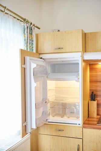 an empty refrigerator with its door open in a kitchen at Chalet Haider in Saalbach Hinterglemm