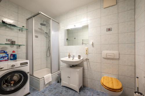 a bathroom with a sink and a washing machine at Arbio I Local Apart in Sudvorstadt in Leipzig