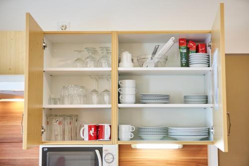 a cabinet filled with plates and cups and dishes at Chalet Haider in Saalbach Hinterglemm