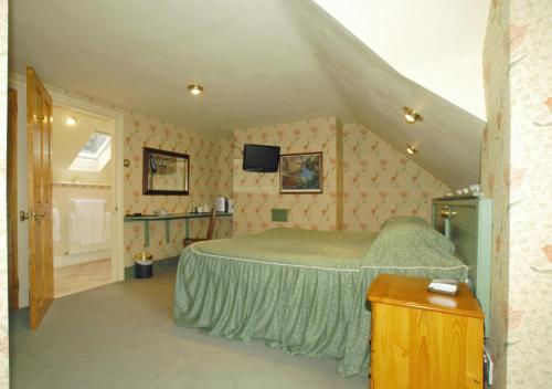 a bedroom with a green bed in a attic at The Stables in Corwen