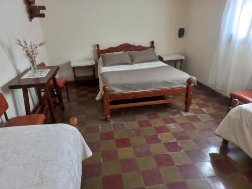 1 dormitorio con 1 cama y suelo a cuadros en Posada El abuelo en Molinos